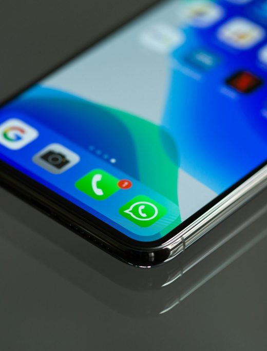 Close-up shot of a smartphone screen displaying various app icons including WhatsApp.
